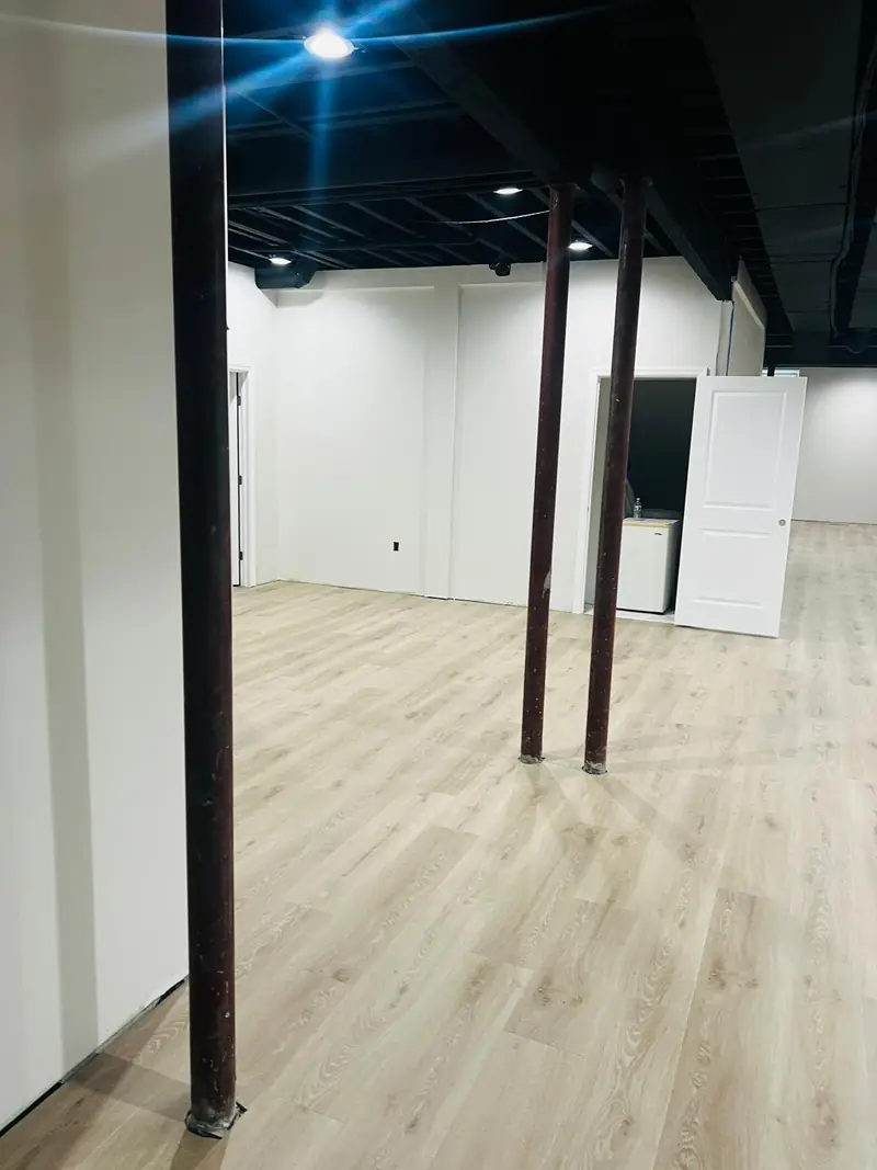 Finished basement with newly installed light oak-look vinyl plank flooring